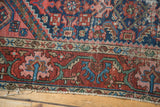 Close-up of the vintage Persian rug's geometric samovar border and tattered fringe.
