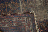 Antique Belouch prayer rug corner, featuring worn pile, exposed foundation, and visible hand-knotted weave.