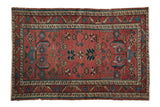 Antique Persian Lilihan rug with wine red allover potted plant motifs, sky blue accents.