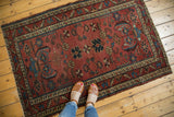 Antique Lilihan rug corner displaying dusty raspberry field, intricate floral motifs, and wear.