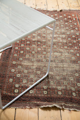 Antique Belouch rug displays repeating geometric motifs, exposed foundation, and worn edges.