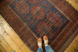 Upper corner of Antique Timuri Belouch rug with brilliant indigo field and serrated terra cotta palmettes.