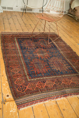 Antique Timuri Belouch rug corner, geometric border, indigo field with serrated palmettes.