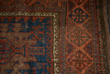 Close-up of antique Timuri Belouch rug; indigo field, serrated palmettes, geometric border.