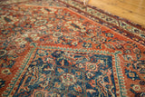 Worn pile texture on a Vintage Mahal rug: terra cotta henna motif, dark blue serrated medallion.