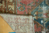 Antique Malayer rug corner, revealing worn pile, blush and blue hues, and hand-knotted foundation.