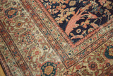 Antique Mahal carpet corner with deep indigo field, peach scrolling vines, and intricate borders.