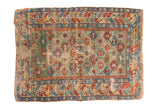 Antique Caucasian rug with a rare green field, featuring vibrant geometric motifs in red, blue, and gold.