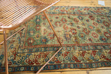 Angled perspective on the brilliant colors and intricate geometric border of an early Caucasian rug.