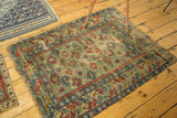 Angled view of an early Caucasian rug, showcasing the rare green field, vibrant geometric motifs, and storied patina.