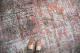 Vintage Mahal carpet with faded rose, ivory, charcoal floral bouquet and visible pile wear.