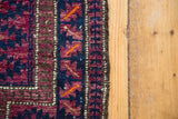 Vintage Belouch rug edge showing unusual violet, navy serrated gul design, goat hair selvedge.