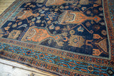 Antique Afshar rug's indigo field, geometric terra cotta patterns, and detailed border, showing wear.