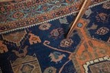 Antique Afshar rug close-up showing dark indigo field, terra cotta geometric motifs, and even wear.