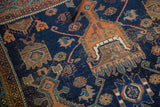 Dark indigo field of antique Afshar rug with geometric planted vase motifs and mostly even wear showing knot heads.