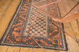 Pale rust and charcoal star burst pattern on vintage camel hair Belouch rug with light tatter.