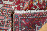 Hand-knotted Karaja rug showing cherry red pile, white fringe, and geometric reverse pattern.