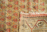 Worn vintage Mir Arak rug corner, displaying saffron pile, tattered fringe, and hand-knotted back.