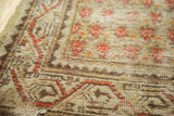 Worn pile and visible foundation of a vintage Mir Arak rug with tangerine floral patterns.