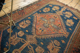 Vintage Kurdish Malayer rug with aged texture, rust orange border, and indigo geometric patterns.