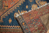 Vintage Persian Kurdish Malayer rug's folded end with tattered fringe, teal blue and rust orange patterns.
