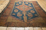 Vintage Kurdish Malayer rug corner, showing a worn rust border and tattered edge.