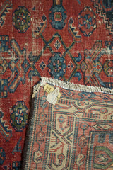 Folded vintage Malayer runner showing worn red pile, semi-herati design, and detailed woven back.
