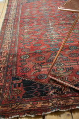 Vintage Malayer runner's semi-herati motifs, cherry red field, indigo details, and wear.