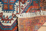 Thick pile, short cream fringe, and hand-knotted foundation detail of a vintage Afshar rug.