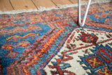 Vintage Afshar rug's thick pile, geometric patterns in blue, orange, red, and ivory.