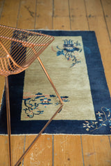 Peking rug corner displaying pictorial blush, apricot, and sky blue floral tendrils.