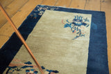 Ivory field and navy border with blue, blush pictorial floral tendrils.