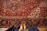 Persian Heriz rug section with rectilinear geometric floral interpretations in cherry red, navy, and mallard green.