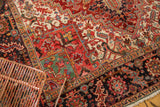 Rectilinear Heriz pattern junction in cherry red, navy, and ivory with visible fringe.