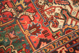 Heriz carpet's detailed geometric florals and serrated leaves in red, green, and ivory.