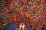 Heriz style vintage rug with rectilinear geometric floral patterns in brick red, navy, and gold.