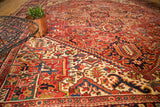 Rectilinear geometric floral interpretations and serrated leaves on the vintage Heriz field in reds and blues.