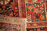 Close-up of vintage Heriz rug's rectilinear patterns, secured edge, and knot wear.