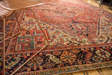 Vintage Heriz rug with dark navy border, brick red, and mallard green rectilinear motifs.