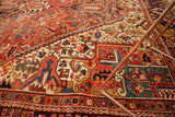 Rectilinear Heriz carpet field with geometric floral designs in brick red, navy, and antique ivory.