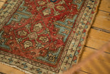 Textured hand-knotted pile with geometric patterns, terra cotta red, watery blue, and secured side.