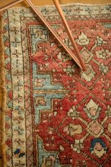 Antique Caucasian rug showing geometric border pinwheels and stepped spandrels in red and blue.