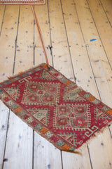 Antique Turkish Yastik rug detail with cinnabar red serrated hook motifs and tattered, worn pile.