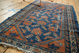 Corner view of vintage Hamadan rug, with cobalt blue field and terra cotta plant motifs.