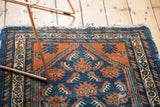 Corner detail of Hamadan rug, with terracotta and cobalt blue serrated leaf motifs.