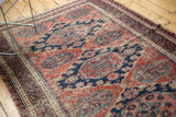 Intricate geometric patterns in navy blue, blush, and madder red on a vintage Caucasian Soumac carpet.