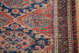Vintage Soumac carpet: intricate geometric patterns, multi-band border, tattered side.