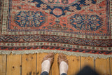 Intact macrame fringe with geometric borders in navy blue and faded madder red.