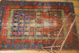 Vintage Caucasian rug detail: geometric patterns, elongated mehrab, visible foundation wear.