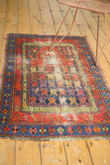 Geometric Caucasian rug with brick red and sky blue borders, an elongated mehrab, and visible pile wear.